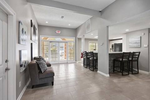 a living room with a couch and a bar with chairs